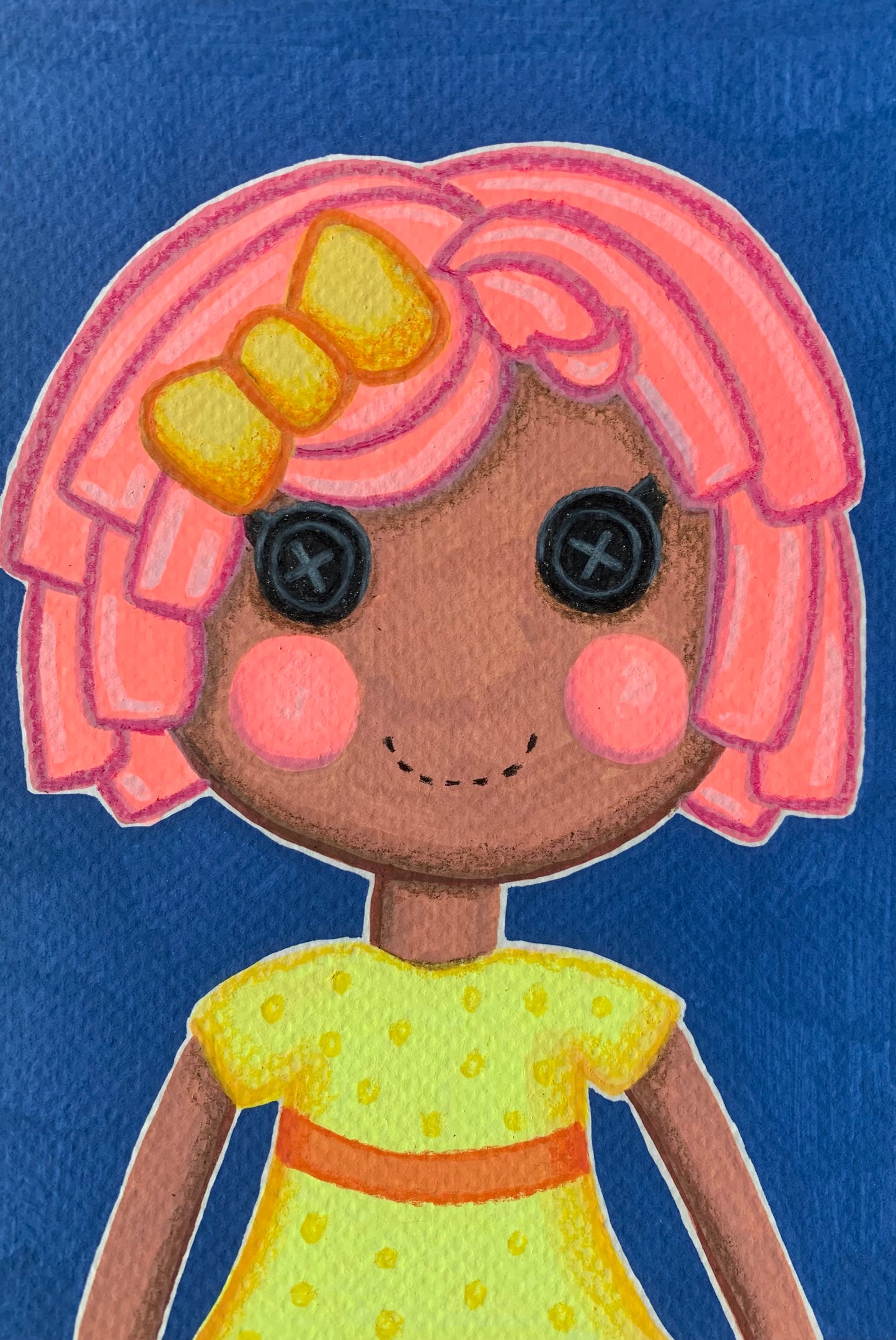 Toy figure with pink hair and a yellow dress on a blue background