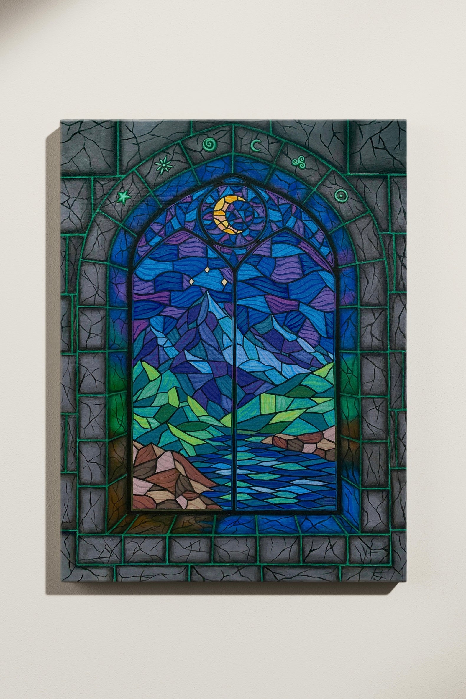 Stained glass window painting with a landscape design featuring a moon, mountains, trees, and water in a stone castle. Displayed on a white wall.