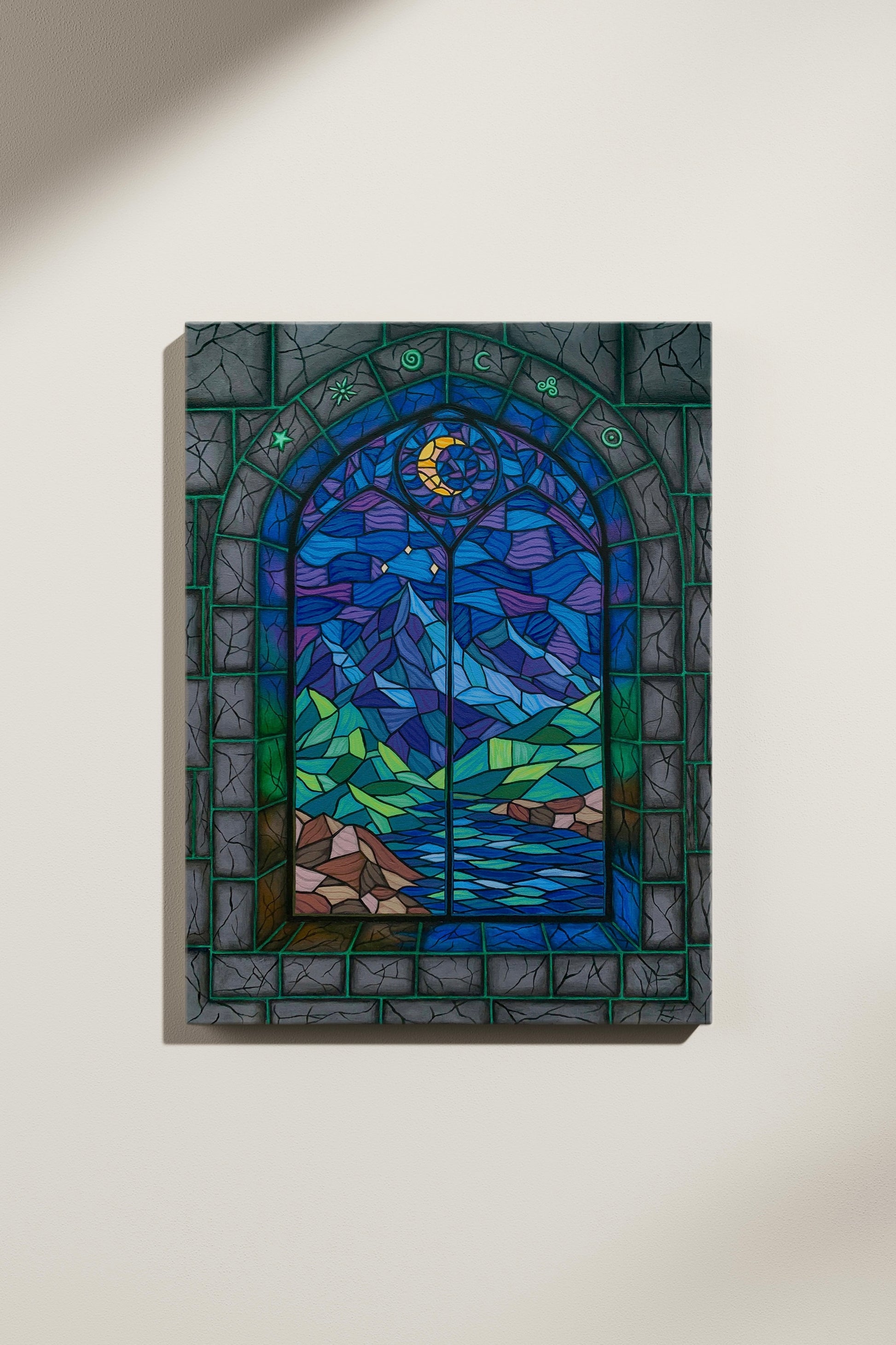 Stained glass window painting with a landscape design featuring a moon, mountains, trees, and water in a stone castle. Displayed on a white wall.