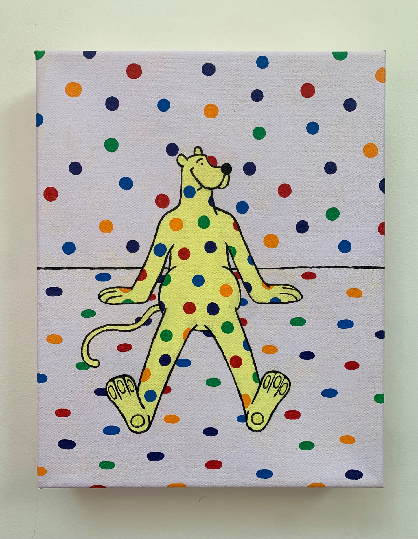 Canvas painting on a white wall of a yellow cartoon leopard character with rainbow polka dot pattern on a polka dot background sitting on the ground