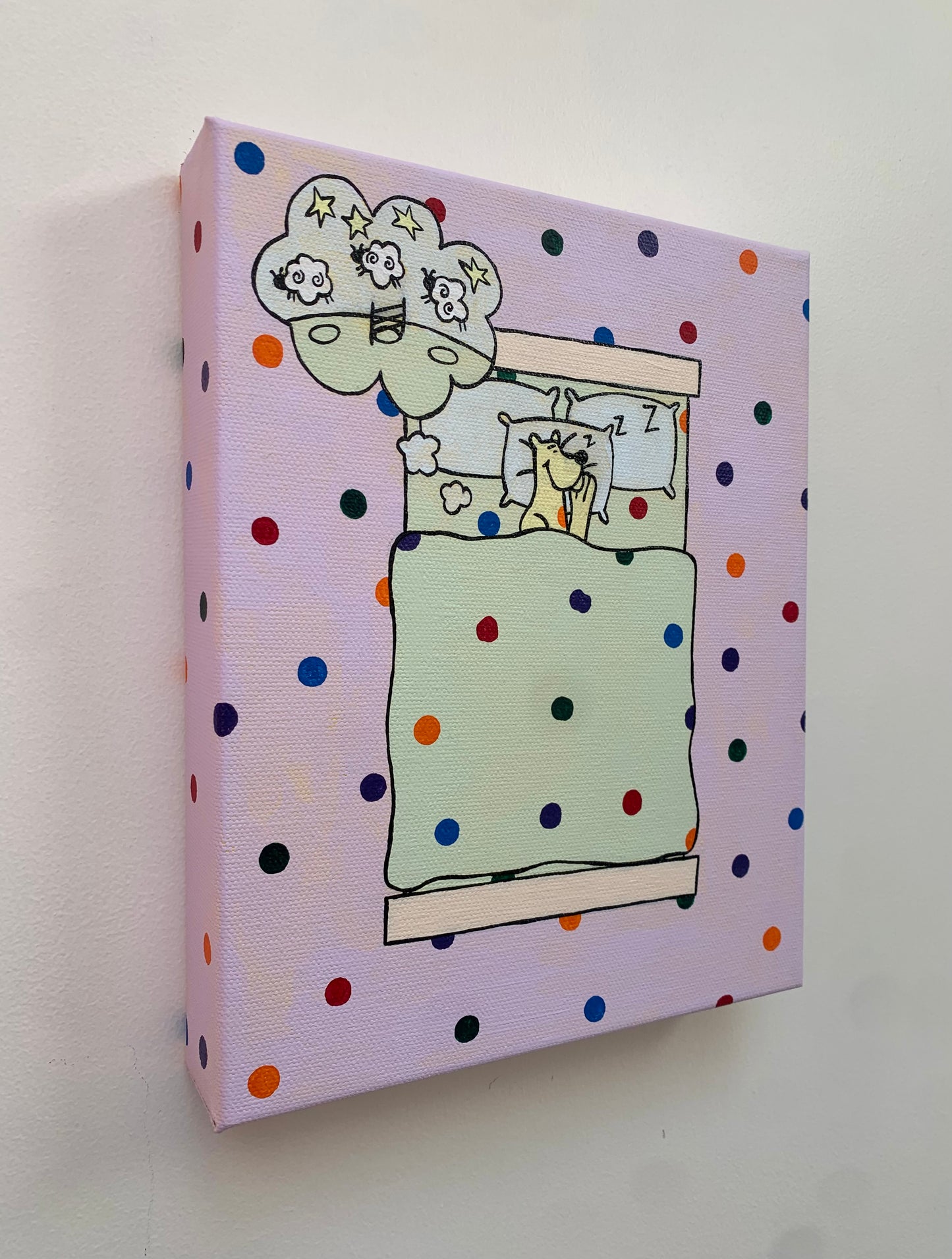 Canvas painting on a white background of a cartoon leopard sleeping in a bed. Overhead view. Dream bubble with the image of sheep jumping over a fence. Rainbow spots all over the background.