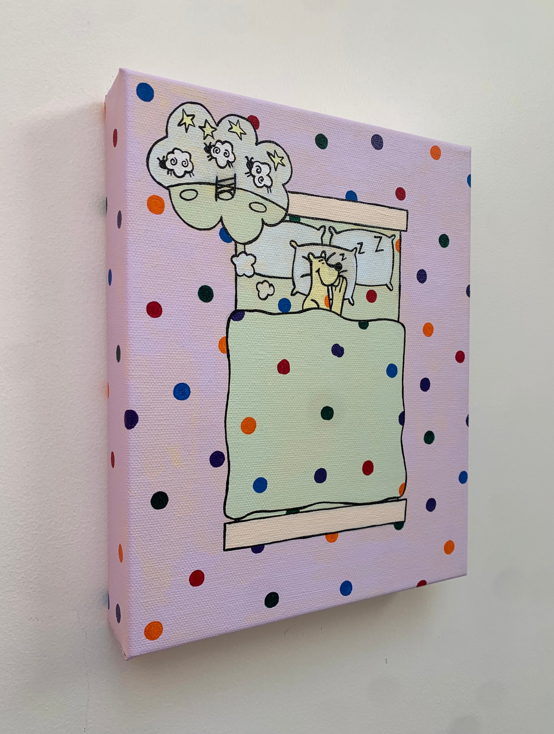 Canvas painting on a white background of a cartoon leopard sleeping in a bed. Overhead view. Dream bubble with the image of sheep jumping over a fence. Rainbow spots all over the background.