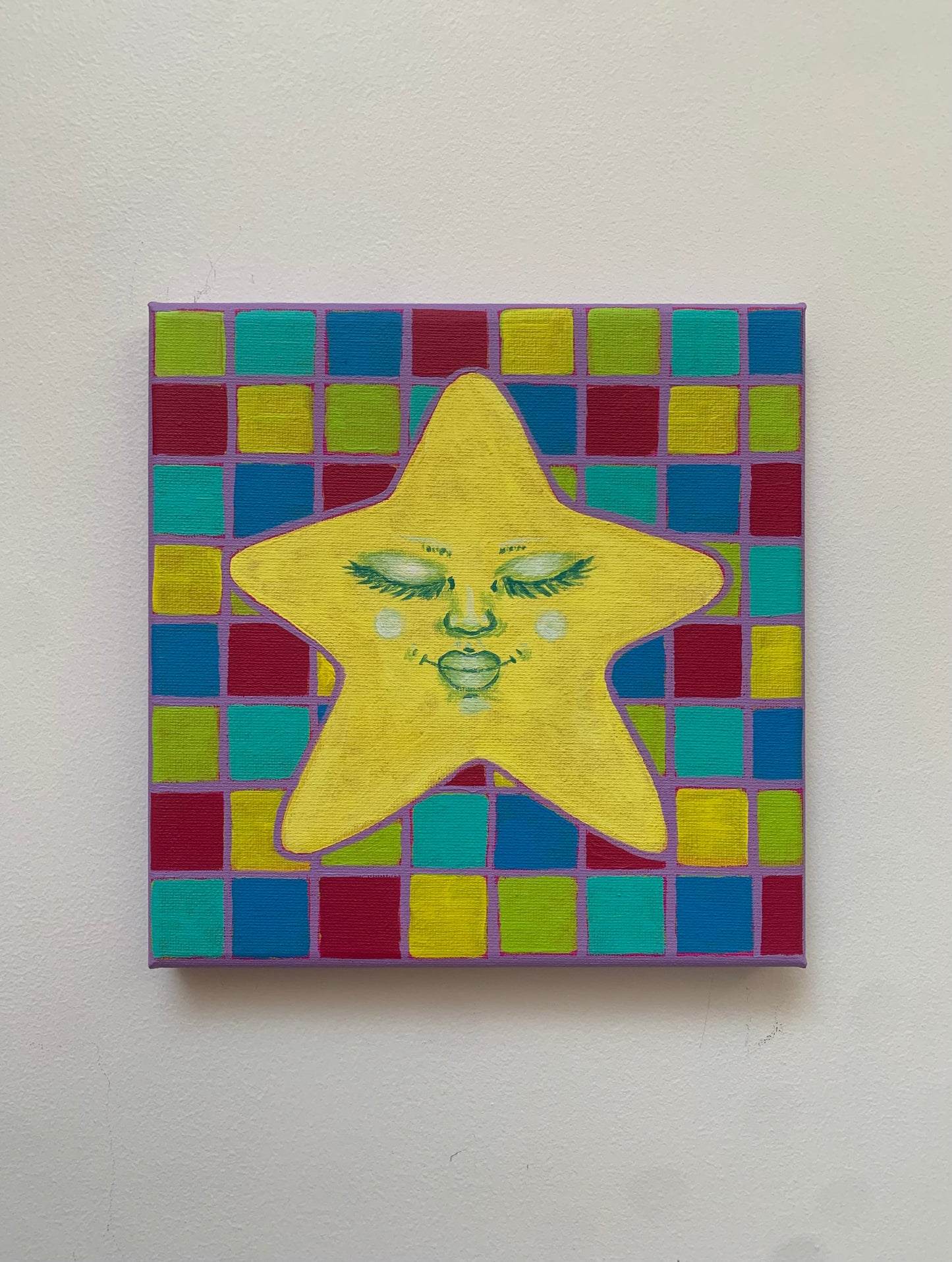 Colorful star-shaped painting with a face on a checkered background