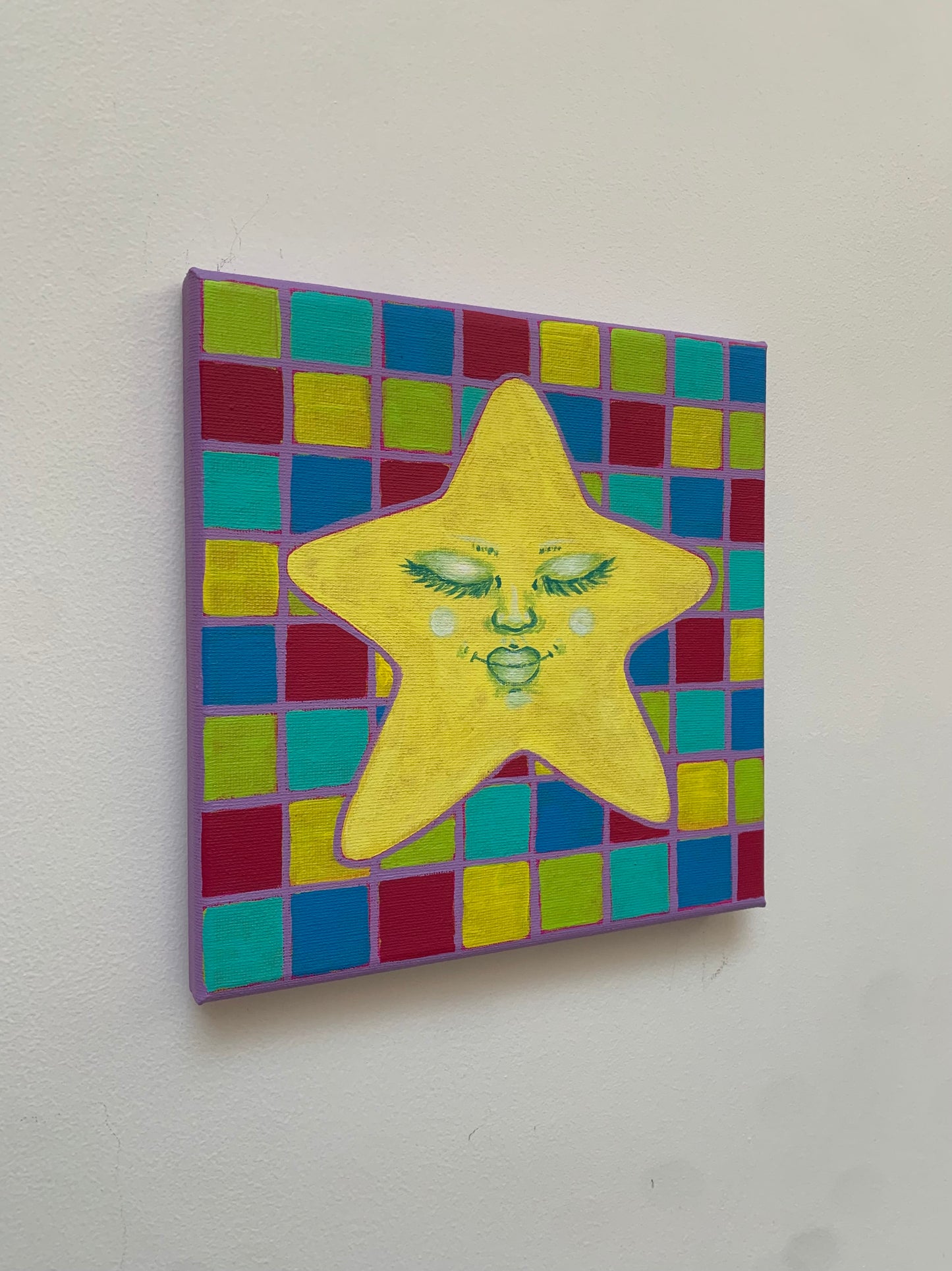 Colorful star-shaped artwork with a face on a checkered background