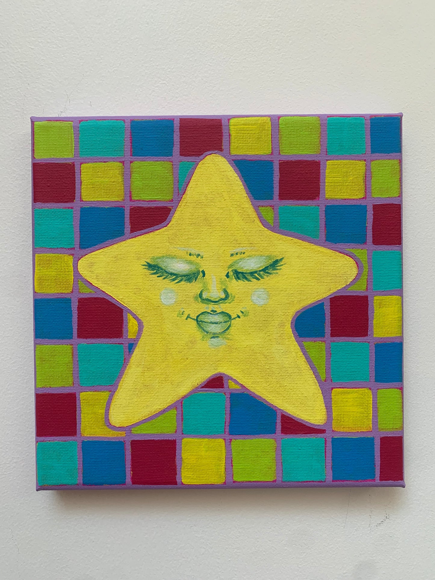 Yellow star-shaped object with green designs on a colorful tiled background