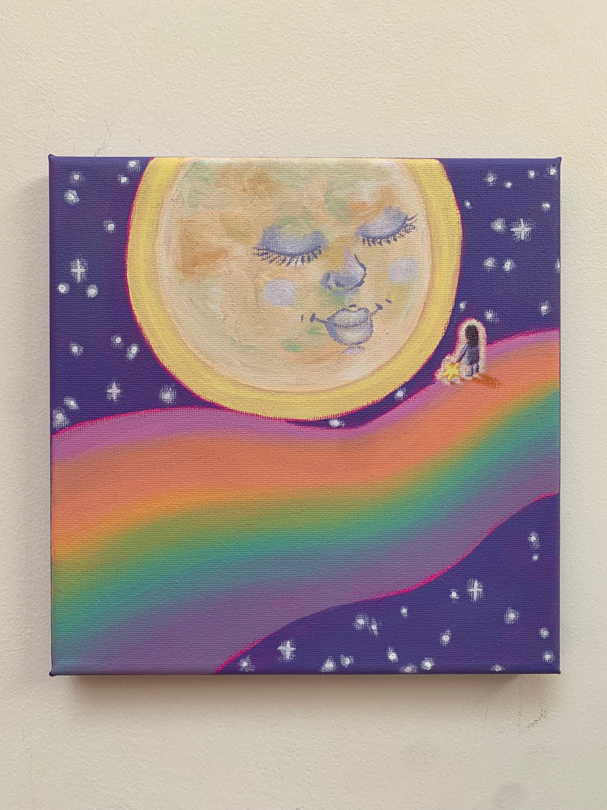 Canvas painting of a moon with facial features, a rainbow, and a small figure on a purple background.