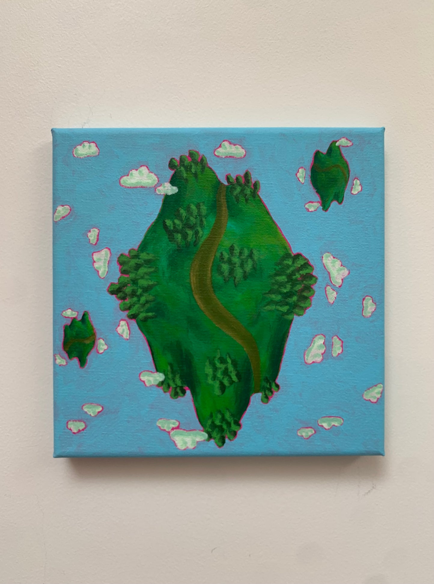 Canvas painting of a green island with a winding path on a blue background