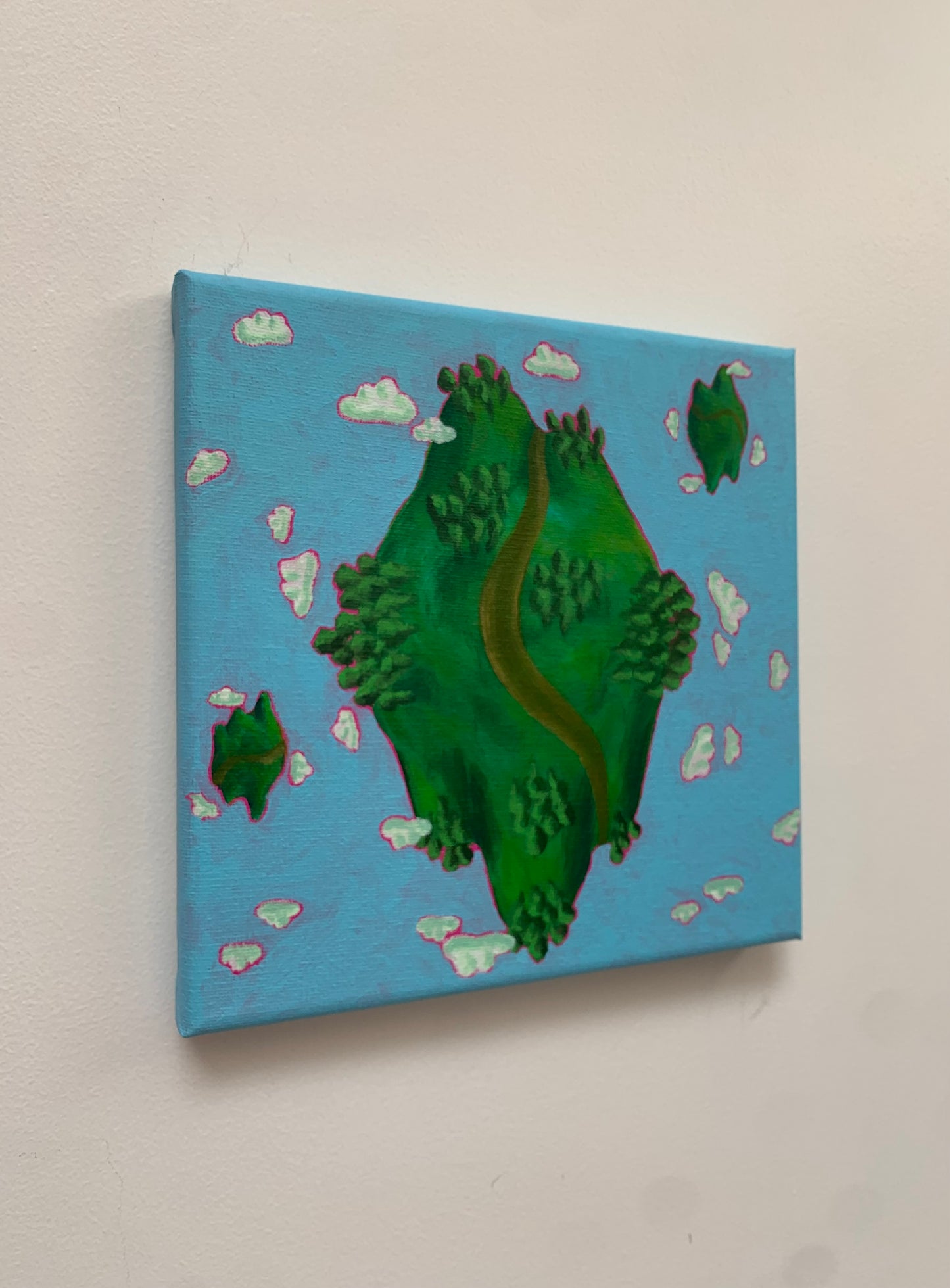Canvas painting of a green planet with clouds on a blue background