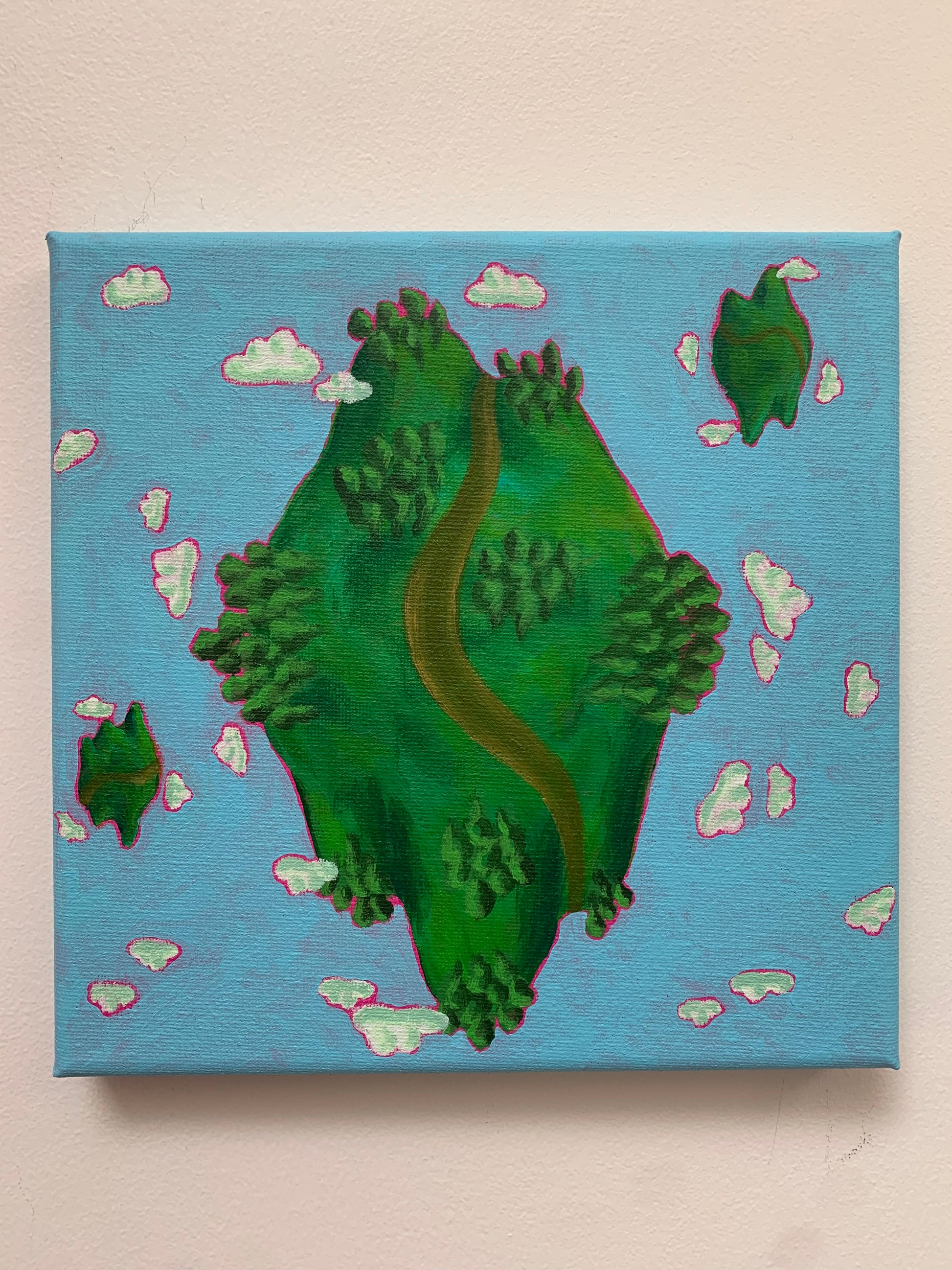 Cartoon-style planet with a road on a blue background with clouds, on a beige surface.